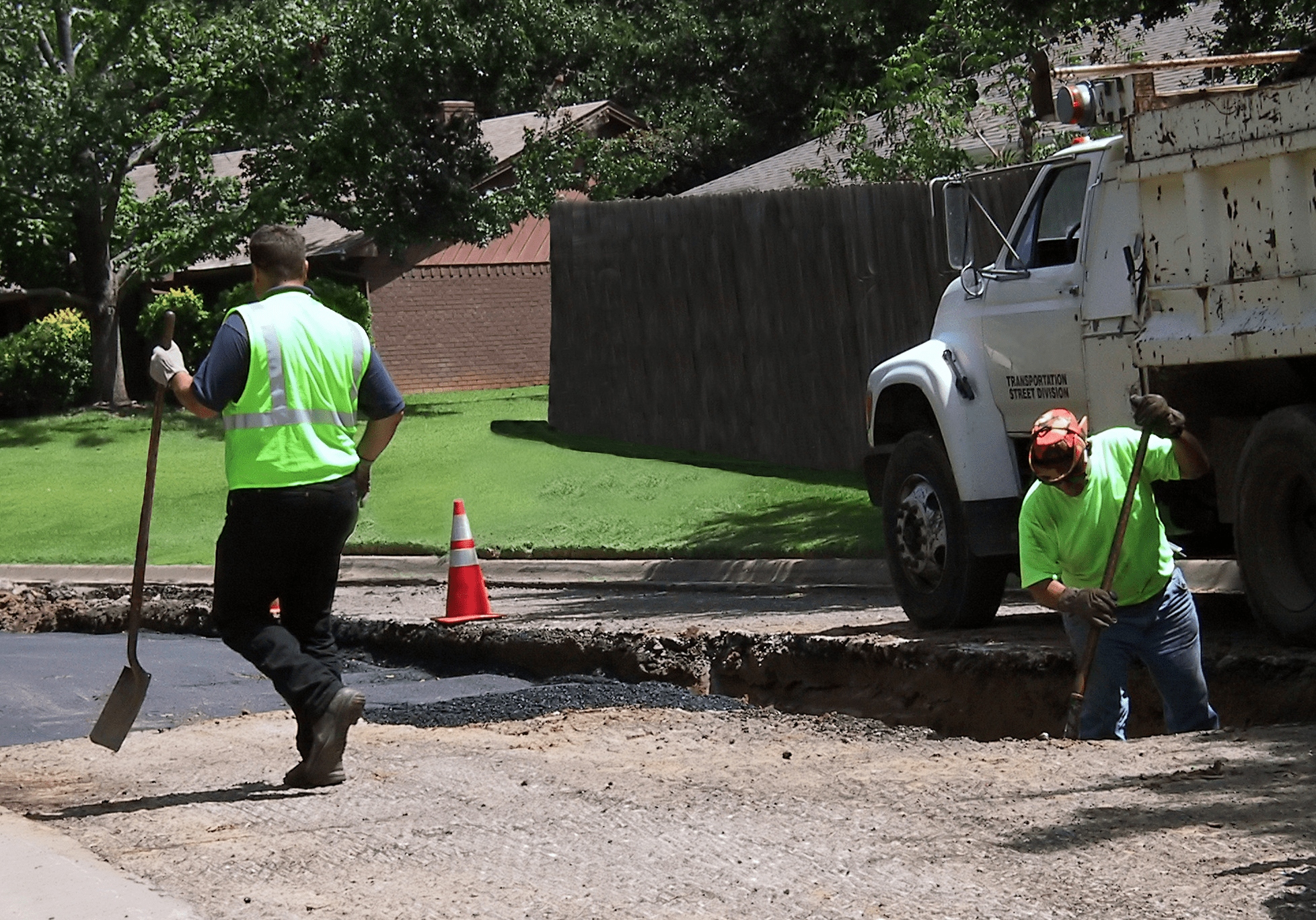 Road construction workers with truck and equipment.