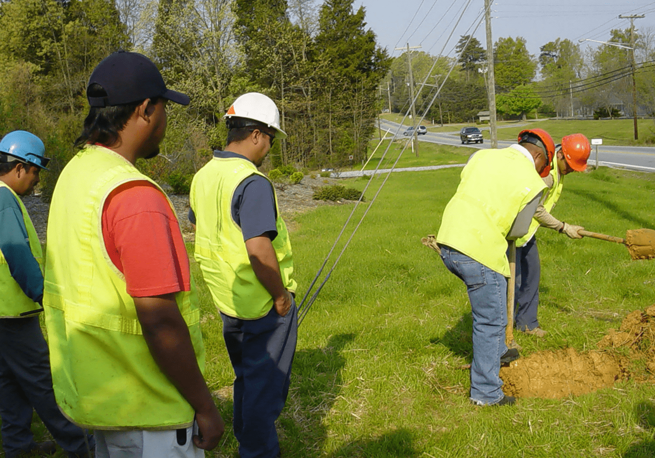 Construction crew working on grassy roadside
